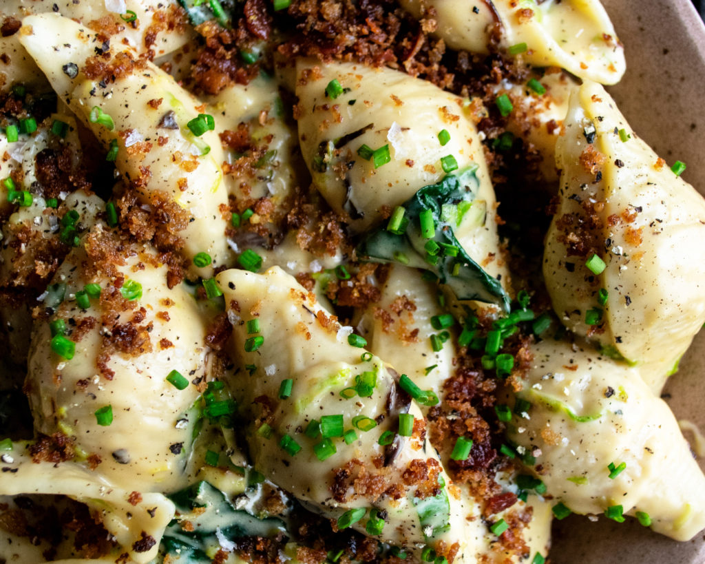 close-up shot of mac and cheese with brussels sprouts and bacon breadcrumbs in bowl