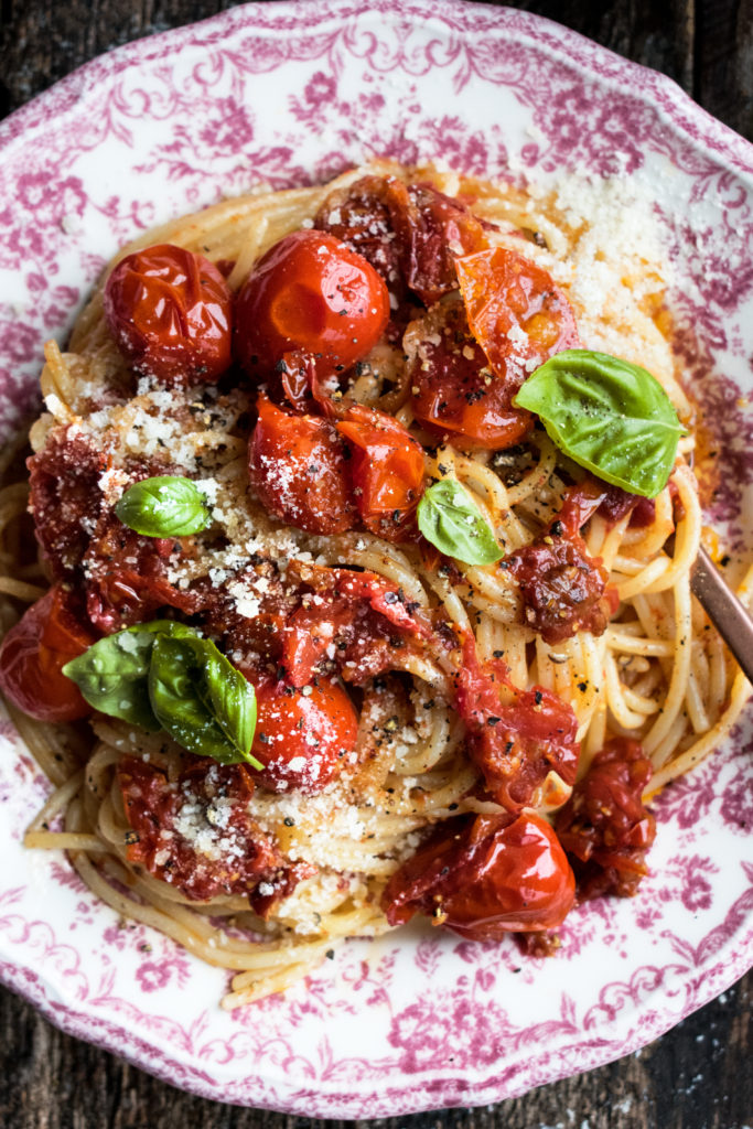 Tomato Confit Spaghetti. A really simple summer pasta recipe that highlights sweet tomatoes in a rich & savory way. Topped with lots of parmesan and basil!