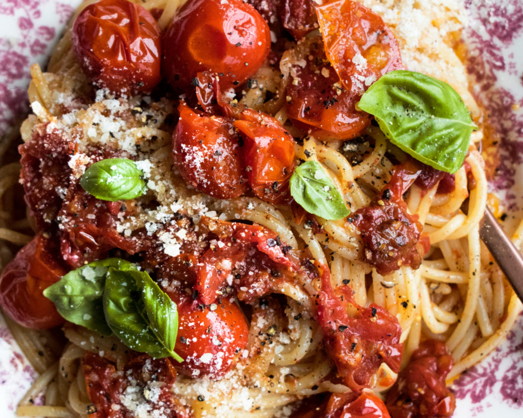 Tomato Confit Spaghetti. A really simple summer pasta recipe that highlights sweet tomatoes in a rich & savory way. Topped with lots of parmesan and basil!