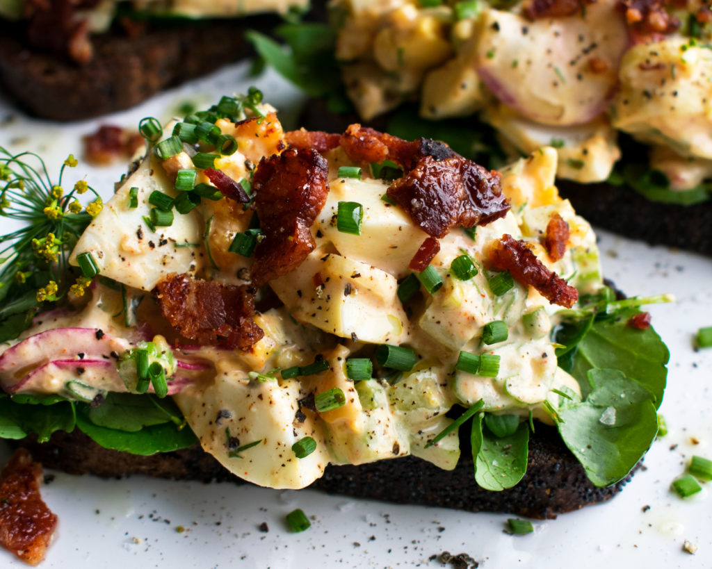 bacon & egg salad on rye toast on a plate