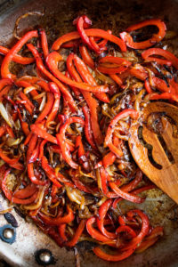 red peppers and onions cooking in a skillet