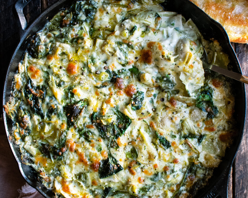 Cheesy Baked Spinach Artichoke Dip in a skillet