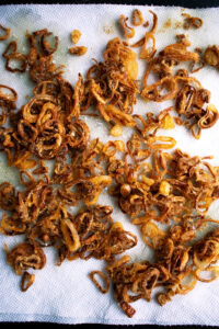 crispy shallots on a paper towel after frying