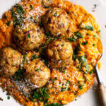 plate of Baked Rosemary Chicken Meatballs over tomato orzo