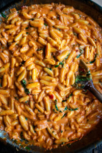 cavatelli in a skillet being tossed with the pasta sauce