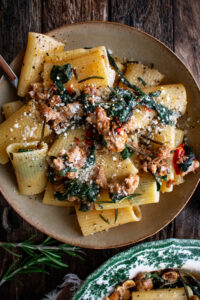 spicy paccheri with sausage and greens in a bowl