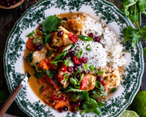 bowl of Thai chicken curry served over rice with toppings
