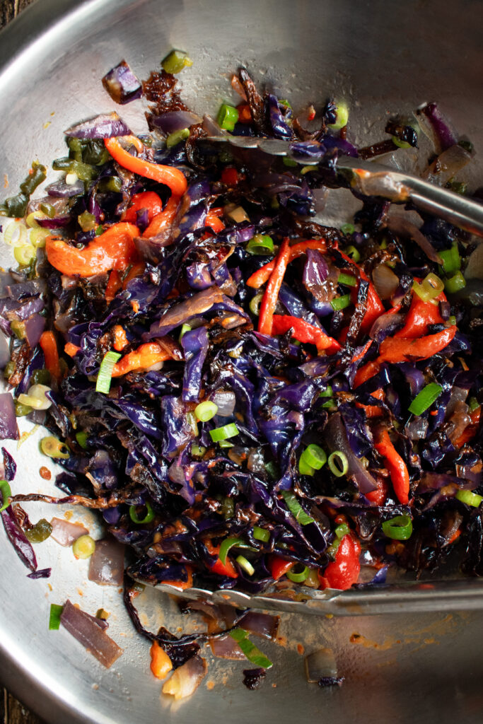 roasted cabbage slaw being mixed in a bowl