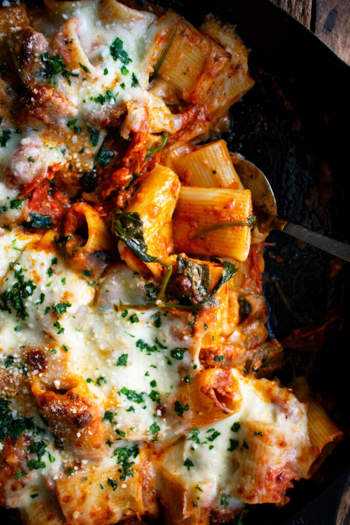 Cheesy Baked Rigatoni with Italian Sausage & Spinach in a skillet