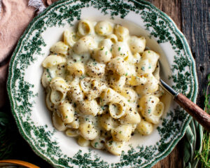 a bowl of herbed mac and cheese topped with black pepper