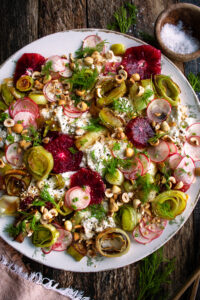 Roasted Leek & Blood Orange Salad with burrata cheese on a serving plate