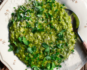 a plate of Spring Pea Risotto with herbs and parmesan over top