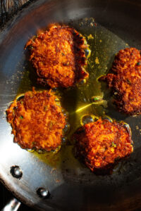 Sweet Potato Fritters shallow-frying in a skillet