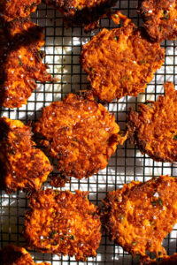 Sweet Potato Fritters with a pinch of flaky sea salt draining on a sheet rack