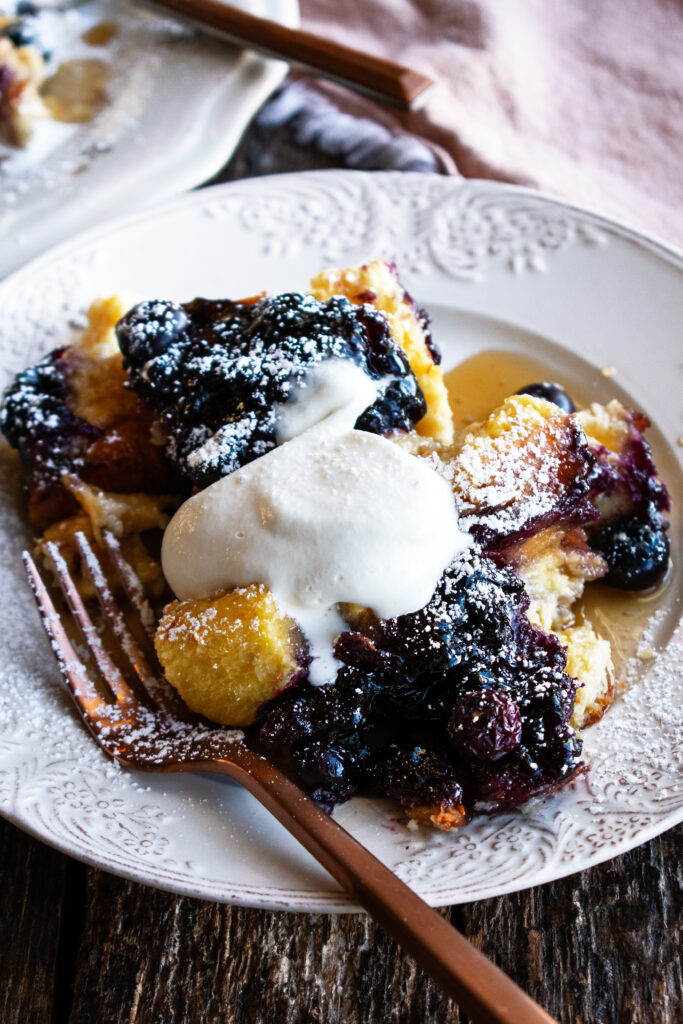Baked Blueberry French Toast on a plate with a dollop of whipped cream on top