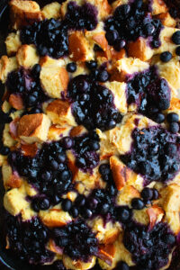 Baked Blueberry French Toast with blueberries and jam on top in a baking dish right out of the oven
