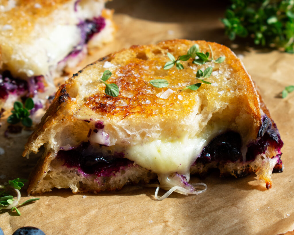 interior view of the Blueberry White Cheddar Grilled Cheese sandwich with melted cheese and jam