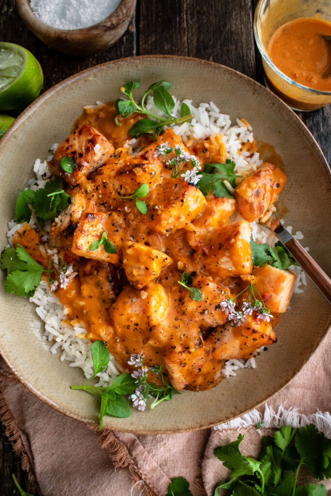 bowl of oven-roasted salmon & rice with creamy coconut tomato sauce