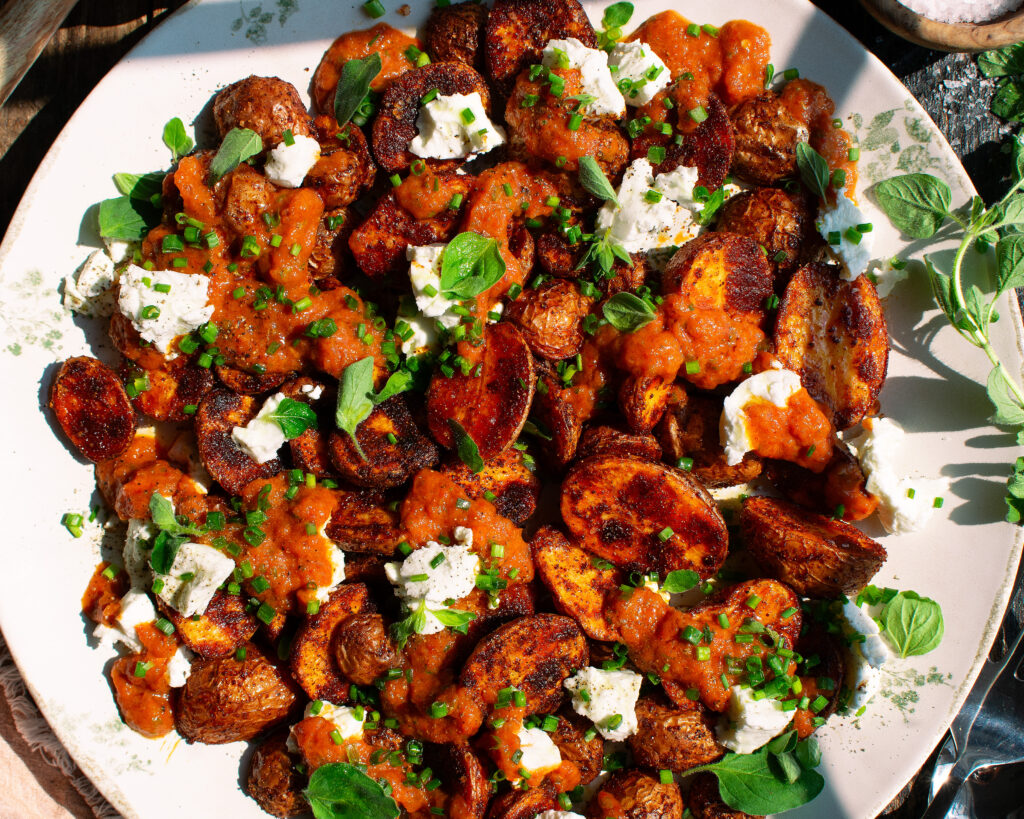 finished plate of roasted potatoes with goat cheese & red pepper sauce