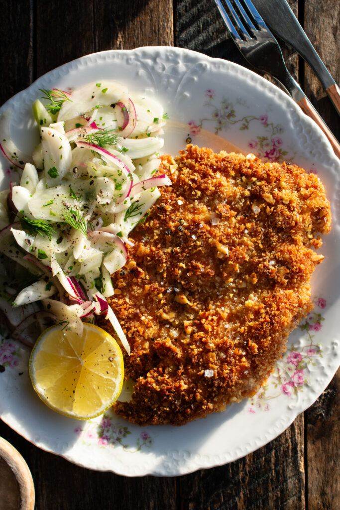 a plate of walnut crusted chicken and fennel slaw