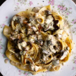 a plate of pappardelle pasta tossed in a creamy mushroom sauce