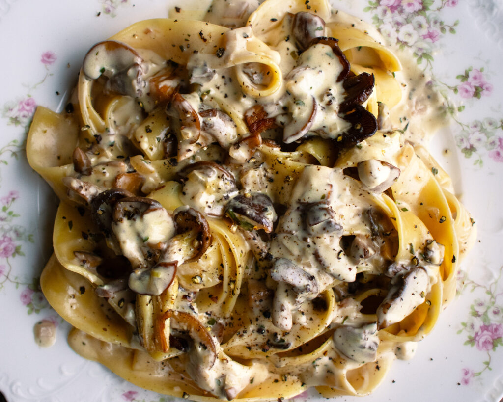 a plate of pappardelle pasta tossed in a creamy mushroom sauce