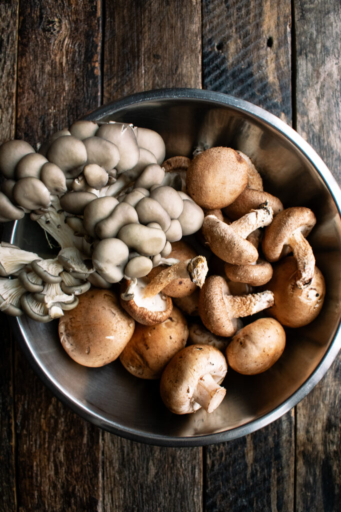 a bowl of cremini mushrooms, shiitake mushrooms, and oyster mushrooms