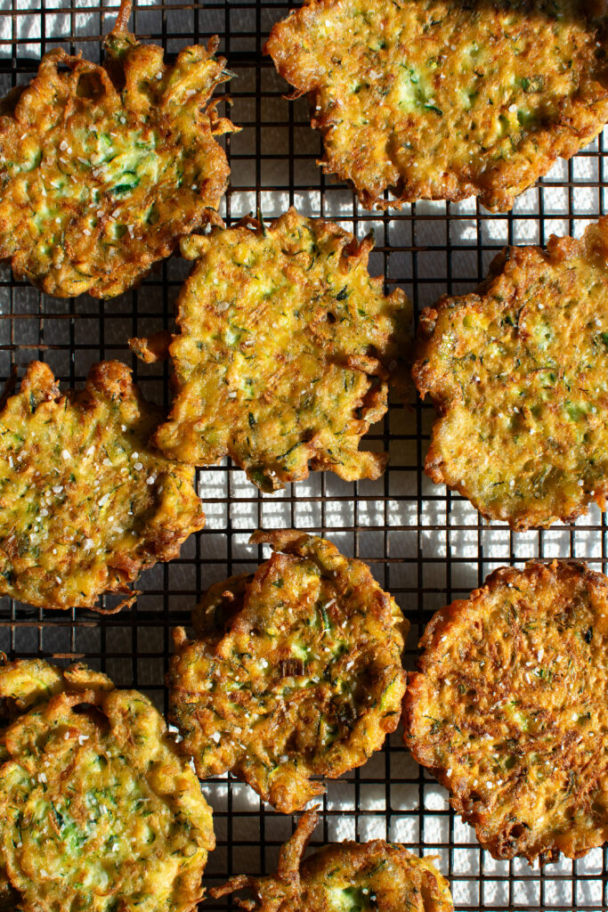 zucchini fritters on a cooling rack after pan-frying