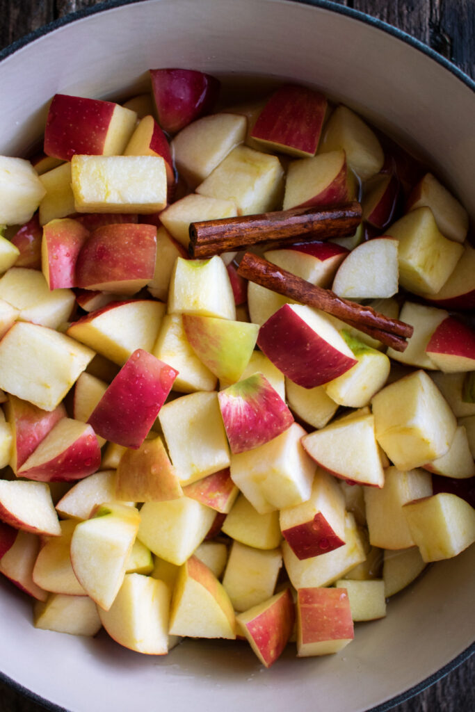 cut apples and cinnamon sticks in a pot