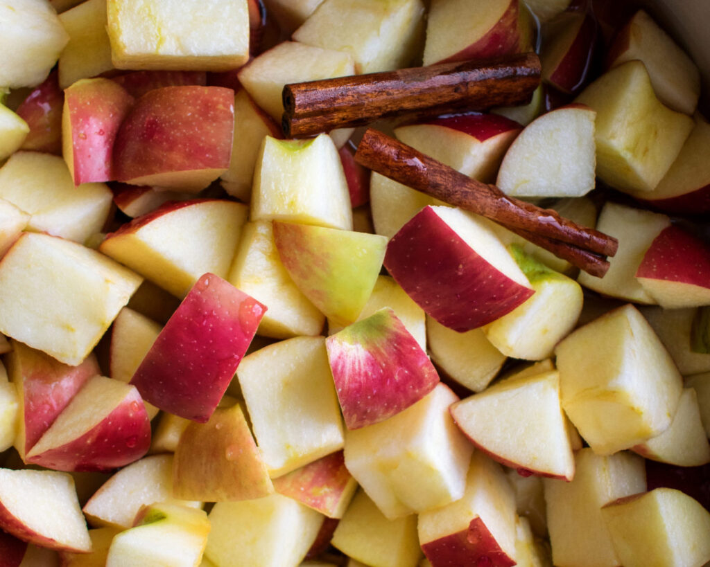 cut apples and cinnamon sticks in a pot