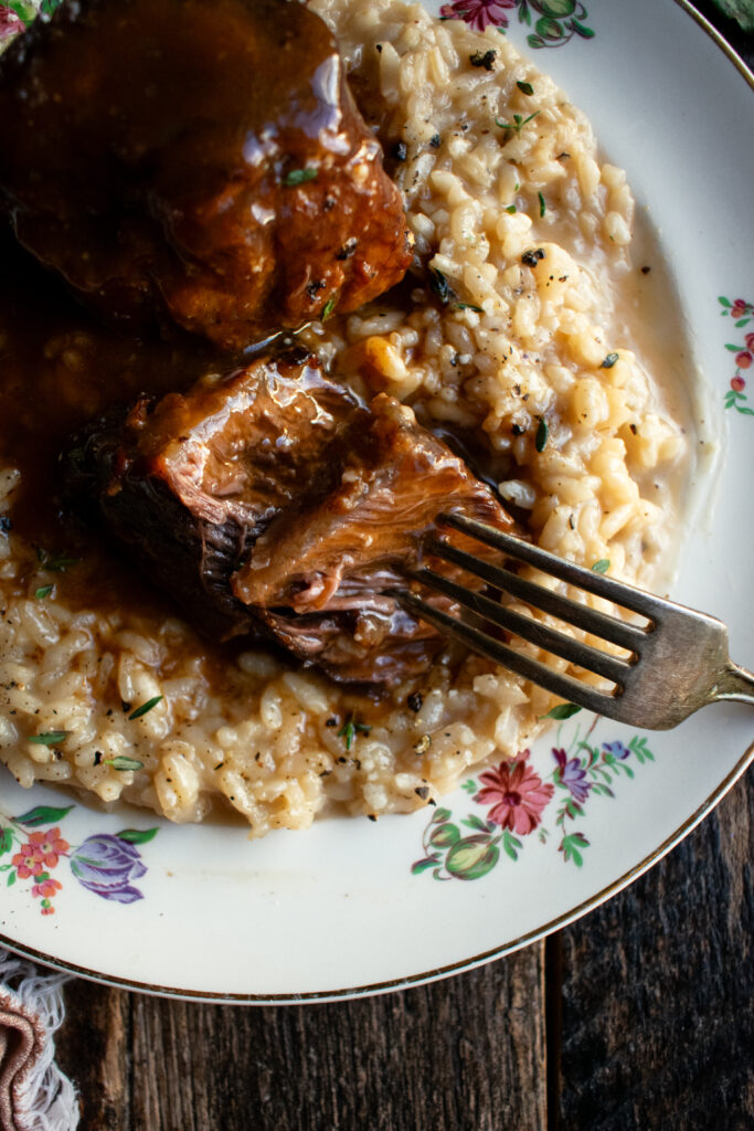 red wine braised short ribs over parmesan risotto on a plate