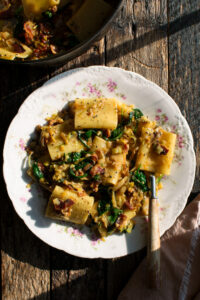 plate of paccheri with leeks, bacon, and spinach