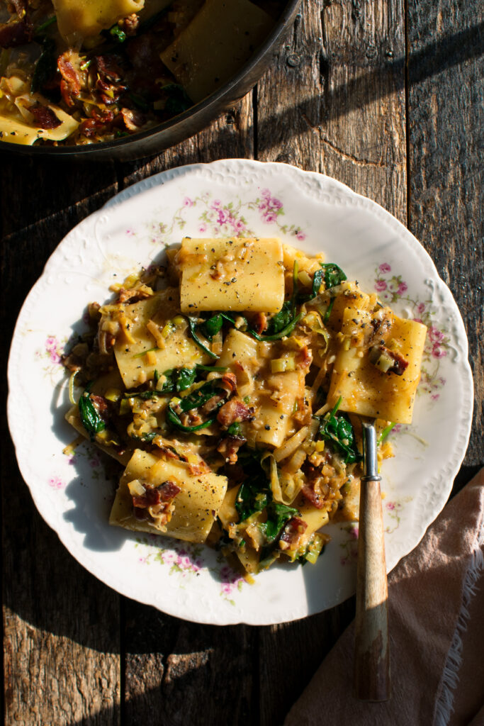 plate of paccheri with leeks, bacon, and spinach