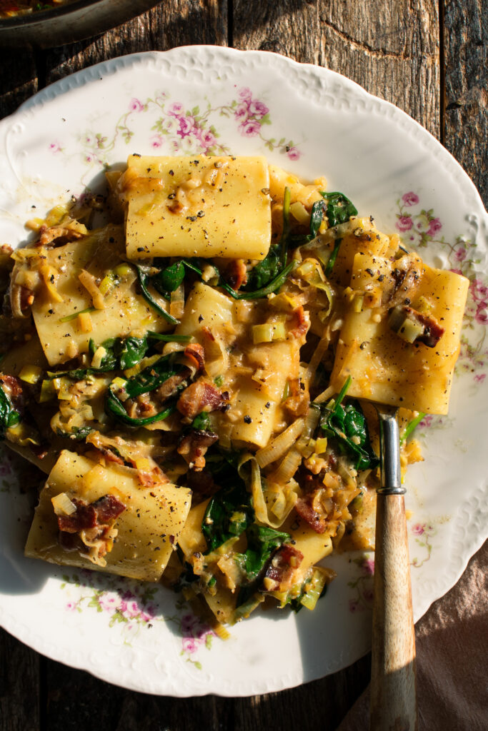 plate of paccheri with leeks, bacon, and spinach